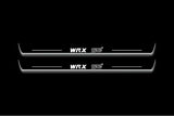 Two long door sill plates with WRX STI lettering and edges illuminated in white, straight-on view on a dark background.