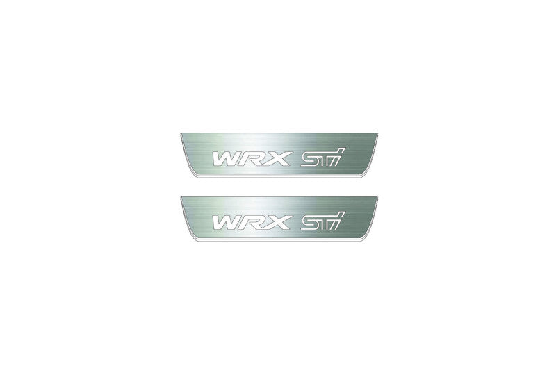 Two short silver-finished door sill plates with WRX STI lettering on a light background, straight-on view.