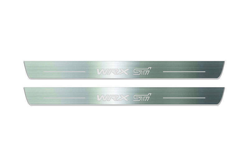 Two long silver-finished door sill plates with WRX STI lettering on a light background, straight-on view.