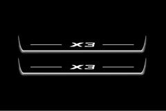 Two long door sill plates with X3 lettering and edges illuminated in white, straight-on view on a dark background.