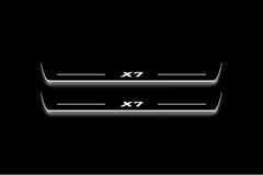 Two long door sill plates with X7 lettering and edges illuminated in white, straight-on view on a dark background.