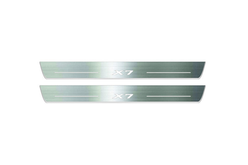 Two long silver-finished door sill plates with X7 lettering on a light background, straight-on view.