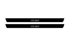 Catalog illustration of two black front door sill plates with XC60 lettering.