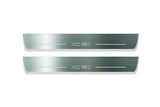 Two long silver-finished door sill plates with XC90 lettering on a light background, straight-on view.