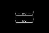 Two short door sill plates with XV lettering and edges illuminated in white, straight-on view on a dark background.