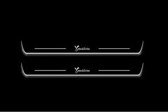 Two long door sill plates with Ypsilon lettering and edges illuminated in white, straight-on view on a dark background.