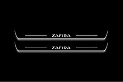 Two long door sill plates with Zafira lettering and edges illuminated in white, straight-on view on a dark background.