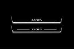 Two long door sill plates with Zafira lettering and edges illuminated in white, straight-on view on a dark background.
