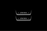 Two short door sill plates with Zafira lettering and edges illuminated in white, straight-on view on a dark background.